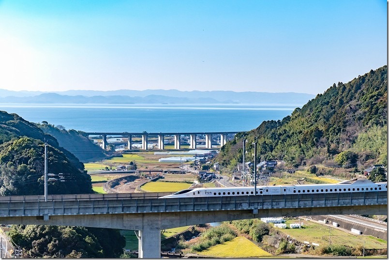 九州新幹線と大村湾の青い海、緑道豊穣の碑展望所。撮影スポット